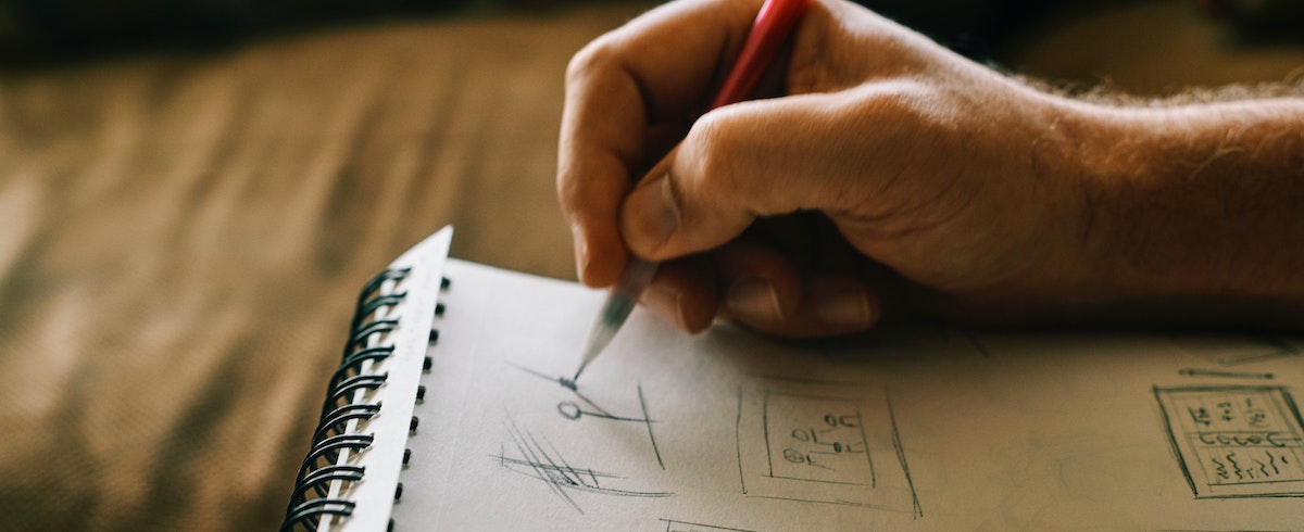 A hand sketching on a notebook